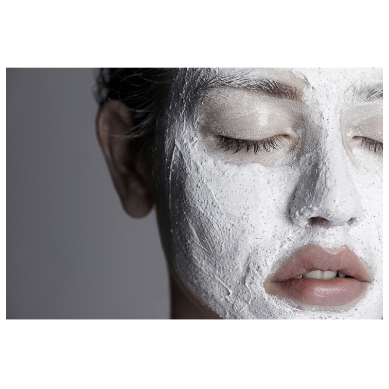 Nahaufnahme eines Gesichts mit geschlossenen Augen, das mit einer weißen Gesichtsmaske bedeckt ist.