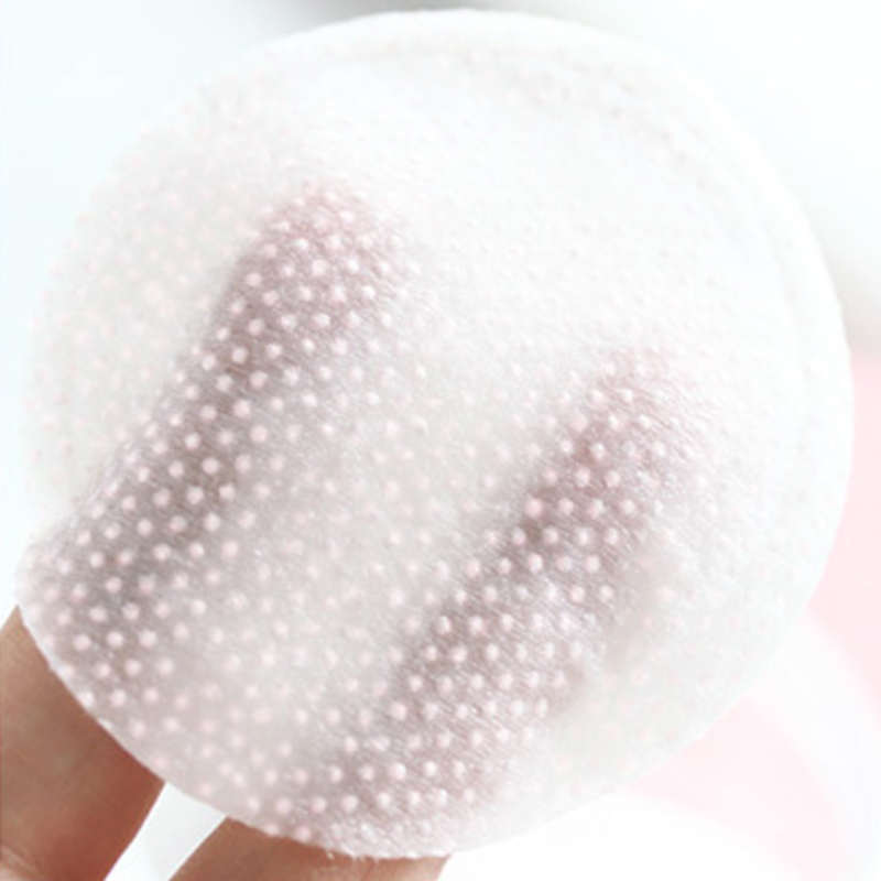 SST074_EAN7640164573175_STARSKIN-R-VIP-7-Second-Luxury-All-Day-Mask-TM-5-Pack_5 Nahaufnahme einer Hand, die ein rundes, gepunktetes Kosmetikpad hält.