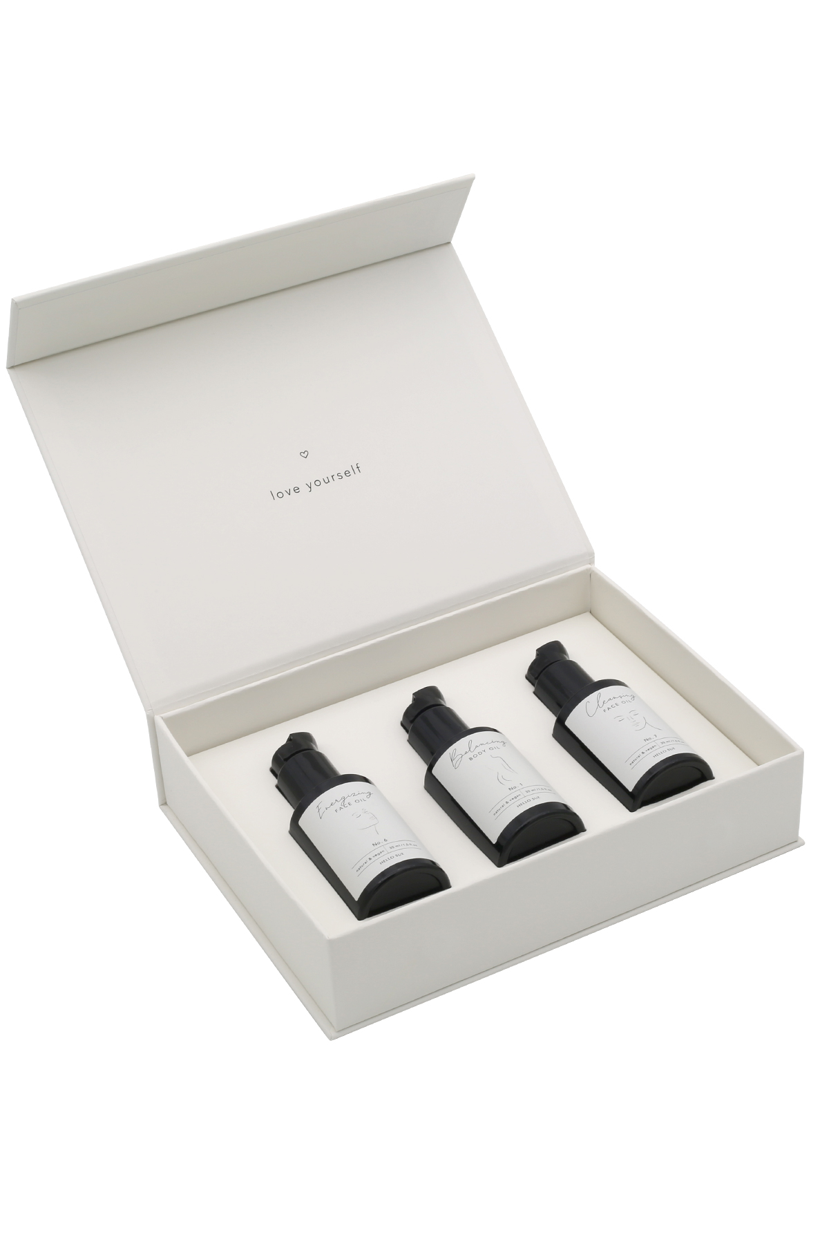 hs-015_facebodyminicollection_freisteller_2 Offene weiße Box mit drei schwarzen Flaschen, beschriftet mit 'love yourself'.