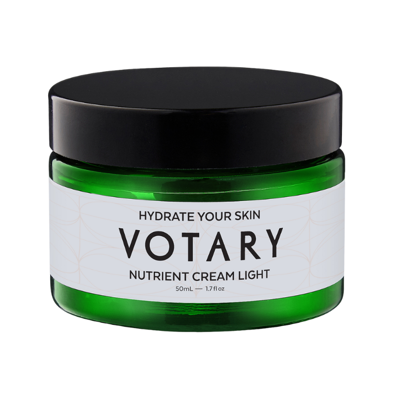 VOTARY-NUTRIENT-CREAM-LIGHT-SUPER-SEEDS-AND-PHYTOCERAMIDES Grünes Glasgefäß mit schwarzem Deckel, beschriftet mit 'VOTARY NUTRIENT CREAM LIGHT'.